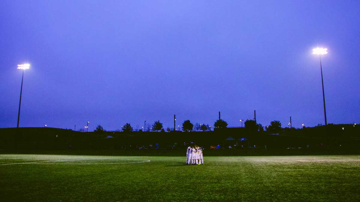Soccer Players huddled under the lights